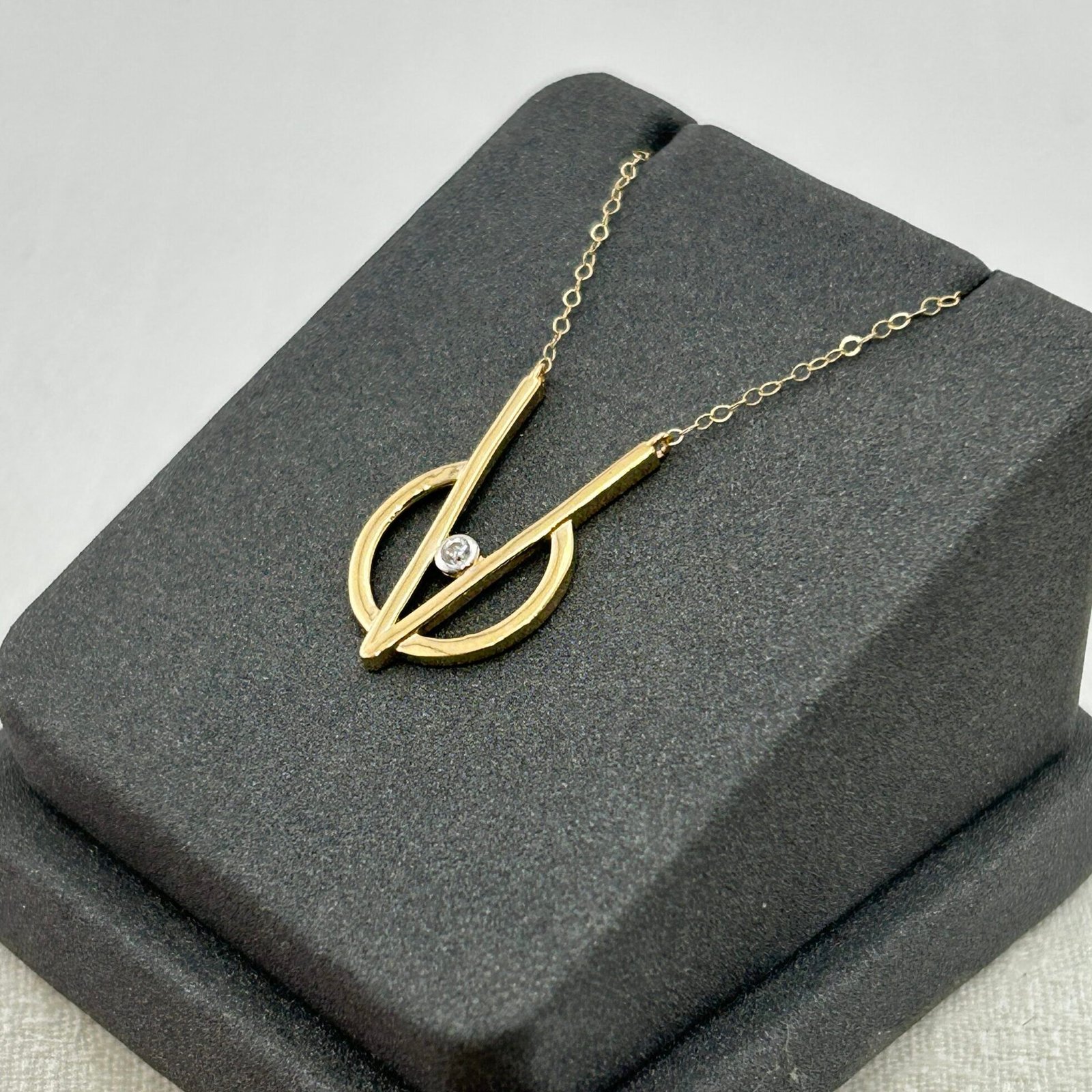 IMG_2727 تعليقة ذهب عيار 18 بدائرة هندسية وحجر لامع مركزي من جولدانا