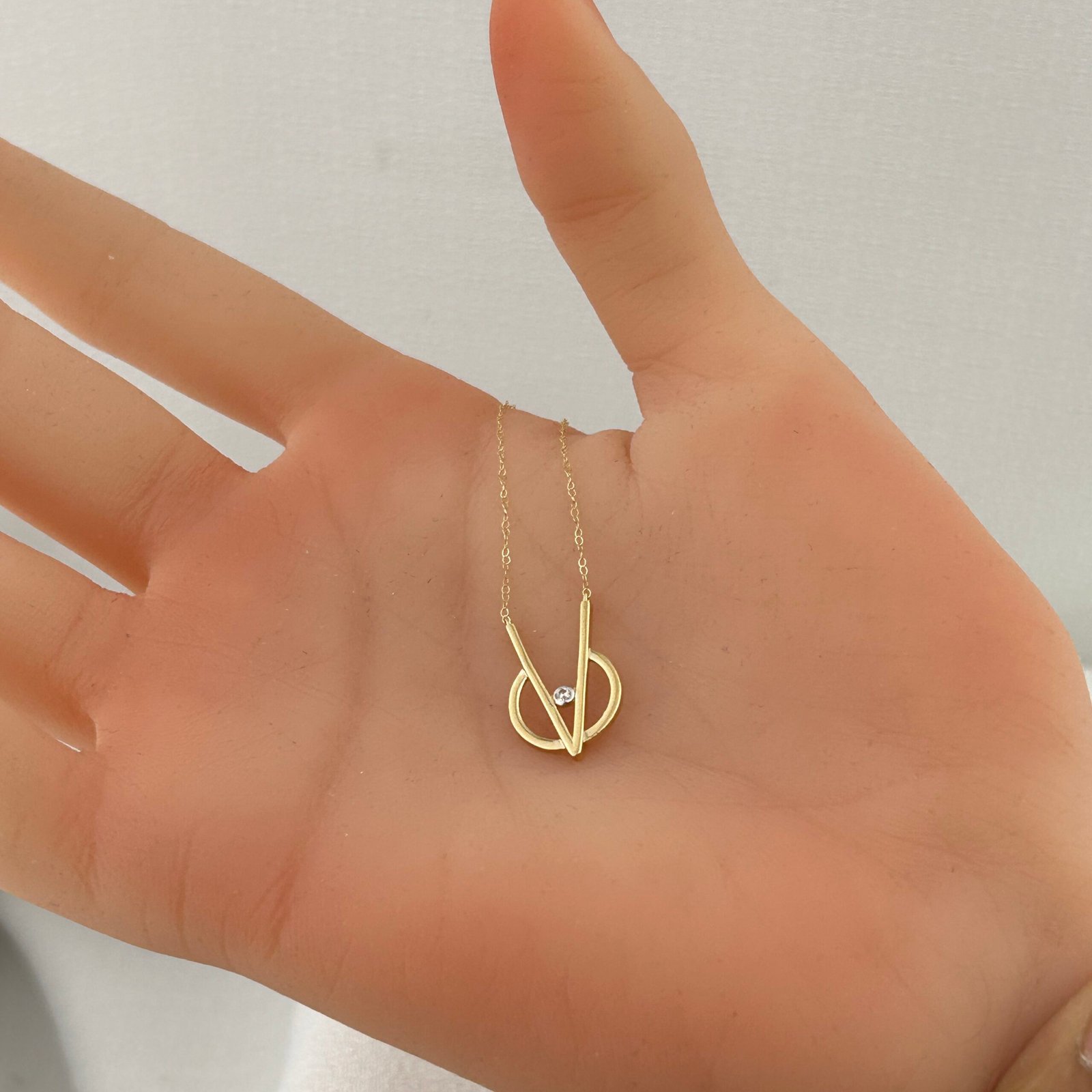 IMG_2728 تعليقة ذهب عيار 18 بدائرة هندسية وحجر لامع مركزي من جولدانا