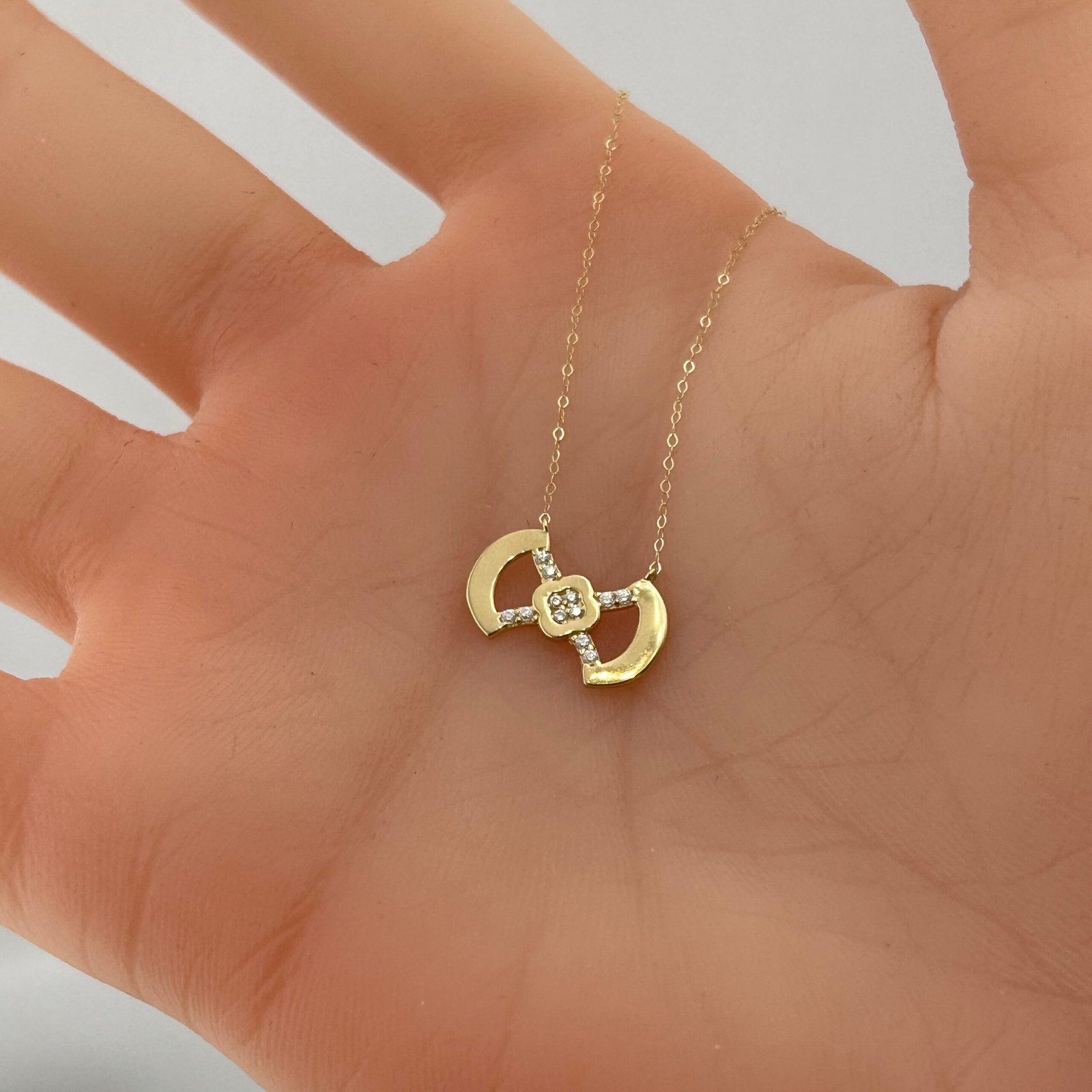 IMG_2781 تعليقة ذهب عيار 18 بتصميم متقاطع مرصع وفص زهري من جولدانا