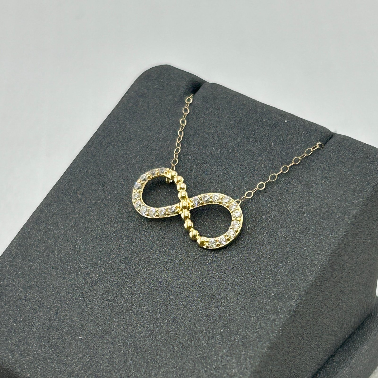 IMG_2827 تعليقة ذهب عيار 18 بشكل رمز اللانهاية مرصعة بفصوص براقة من جولدانا